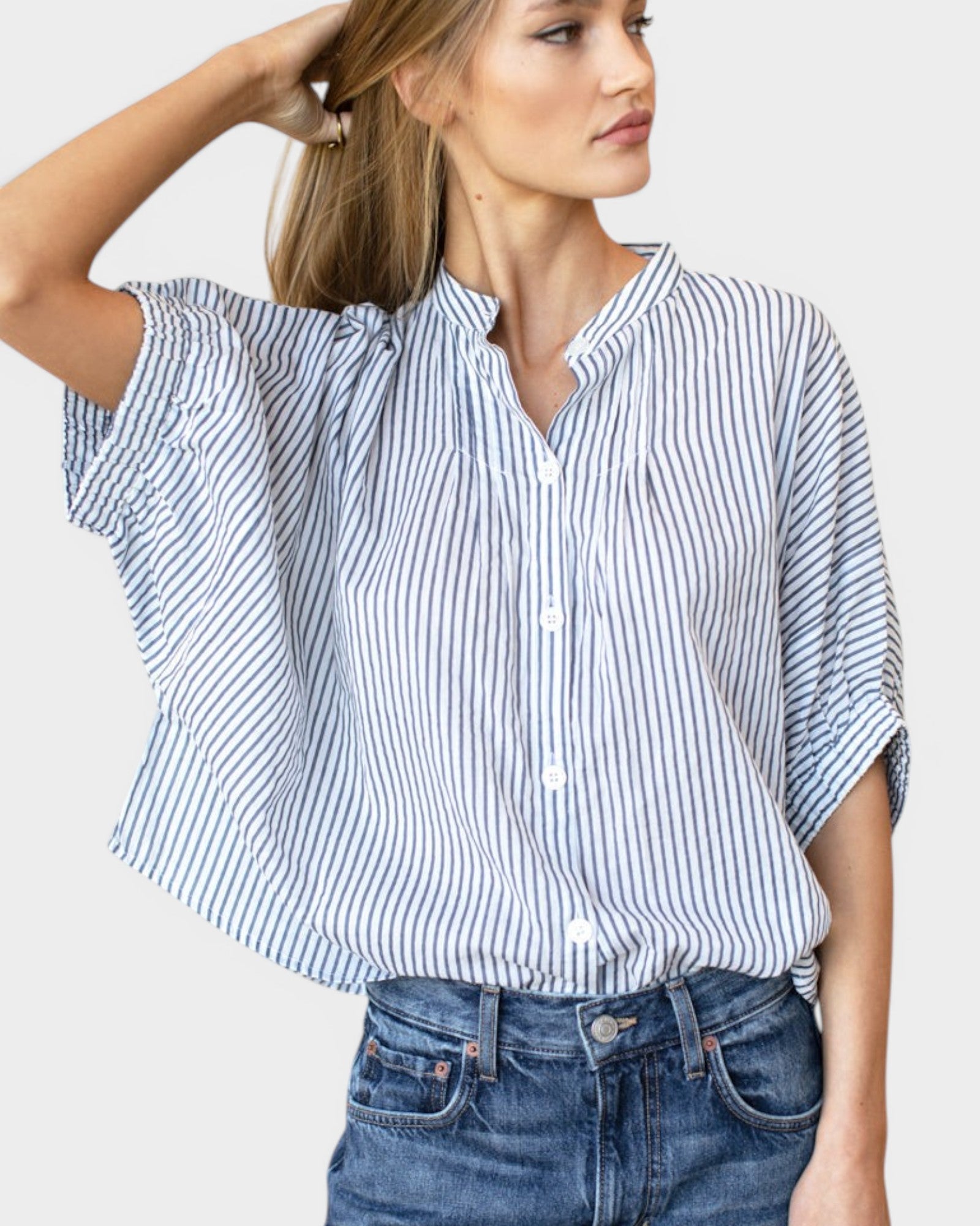 Model wearing a JONES + CO organic cotton blue indigo striped mandarin collar top with batwing sleeves.