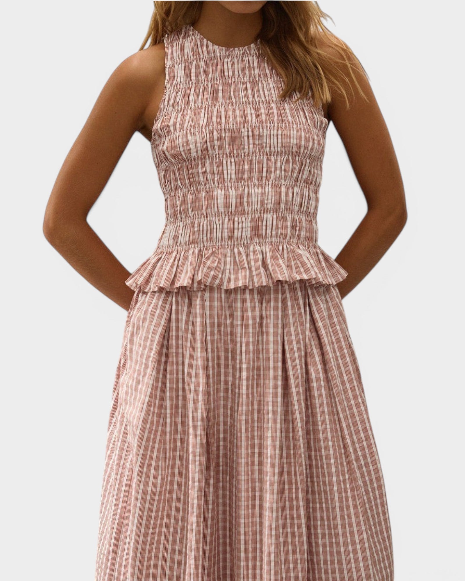 JONES + CO Cales Top in cinnamon white cotton check with a shirred bodice and peplum frill hem on a model.