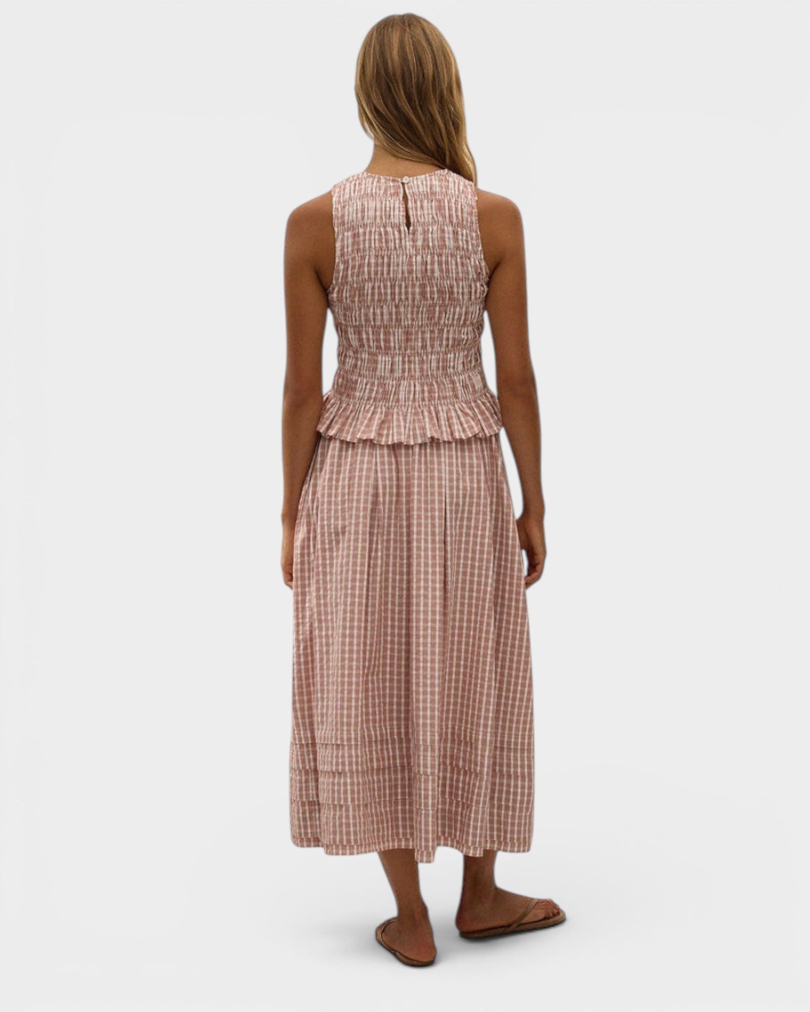 Model wearing JONES + CO Cales Top in cinnamon white cotton check with shirred bodice and peplum hem.