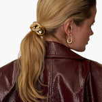 JONES + CO Elena Pave Chain Pony Cuff in 14k gold-plated metal with crystal accents worn on a blonde ponytail.