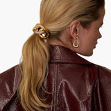 JONES + CO Elena Pave Chain Pony Cuff in 14k gold-plated metal with crystal accents worn on a blonde ponytail.