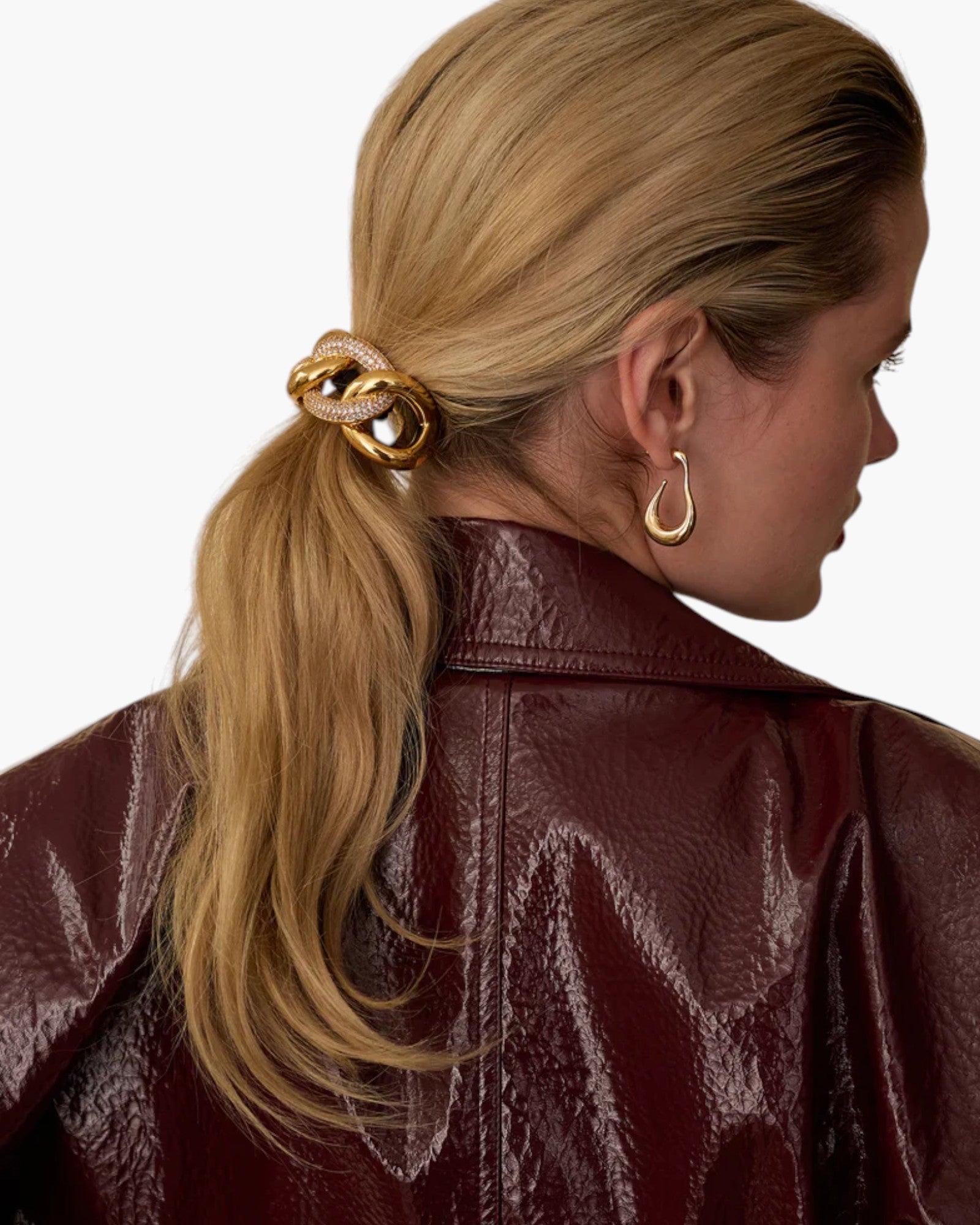 JONES + CO Elena Pave Chain Pony Cuff in 14k gold-plated metal with crystal accents worn on a blonde ponytail.