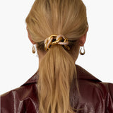 JONES + CO Elena Pave Chain Pony Cuff in 14k gold-plated metal with crystal accents worn on a blonde ponytail.