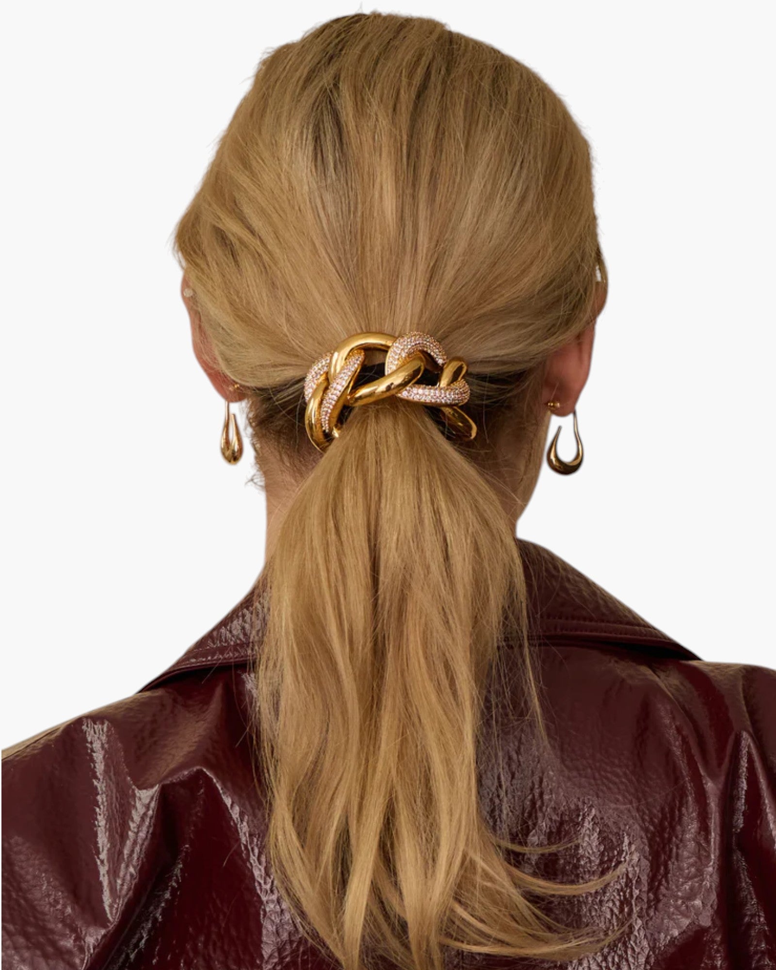 JONES + CO Elena Pave Chain Pony Cuff in 14k gold-plated metal with crystal accents worn on a blonde ponytail.