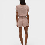 Back view of a model wearing JONES + CO Emilie playsuit in cinnamon and white gingham check with puff sleeves.
