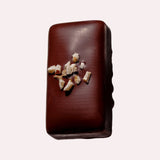 JONES + CO hazelnut butter praline chocolate bar topped with crunchy organic hazelnut pieces on a light background