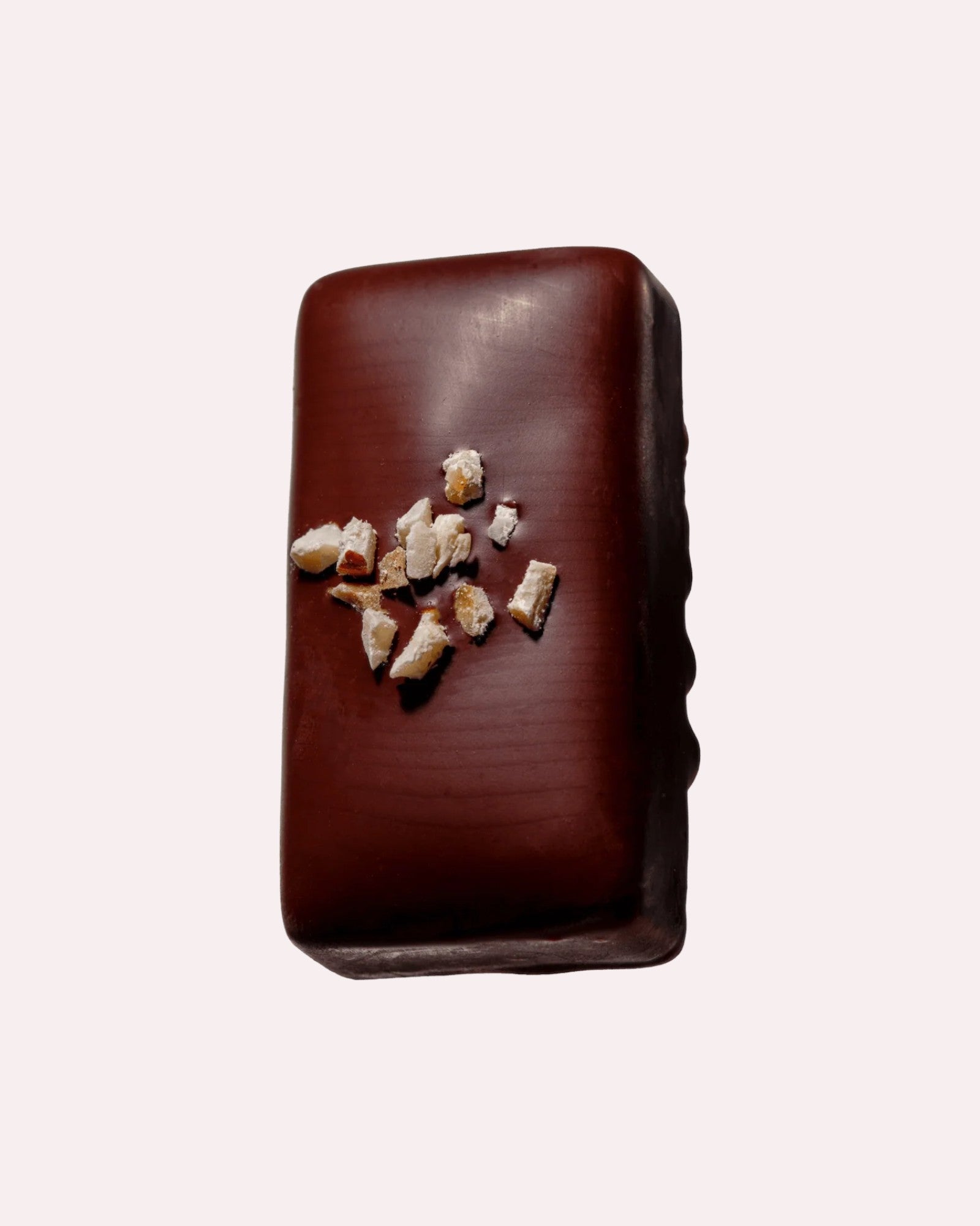 JONES + CO hazelnut butter praline chocolate bar topped with crunchy organic hazelnut pieces on a light background
