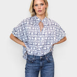 Model wearing JONES + CO organic cotton button-front top in indigo vine print with mandarin collar and batwing sleeves.