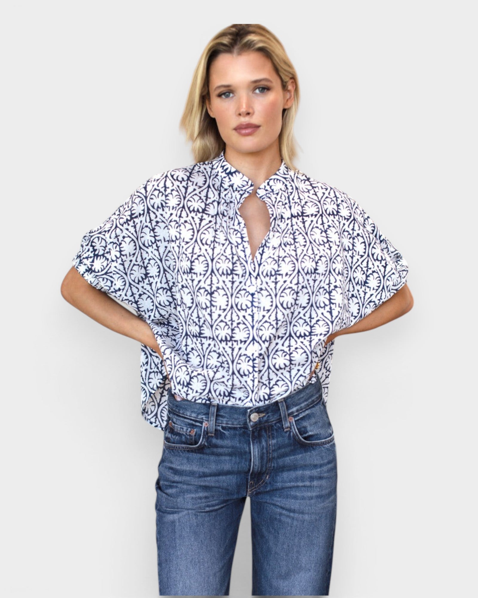 Model wearing JONES + CO organic cotton button-front top in indigo vine print with mandarin collar and batwing sleeves.