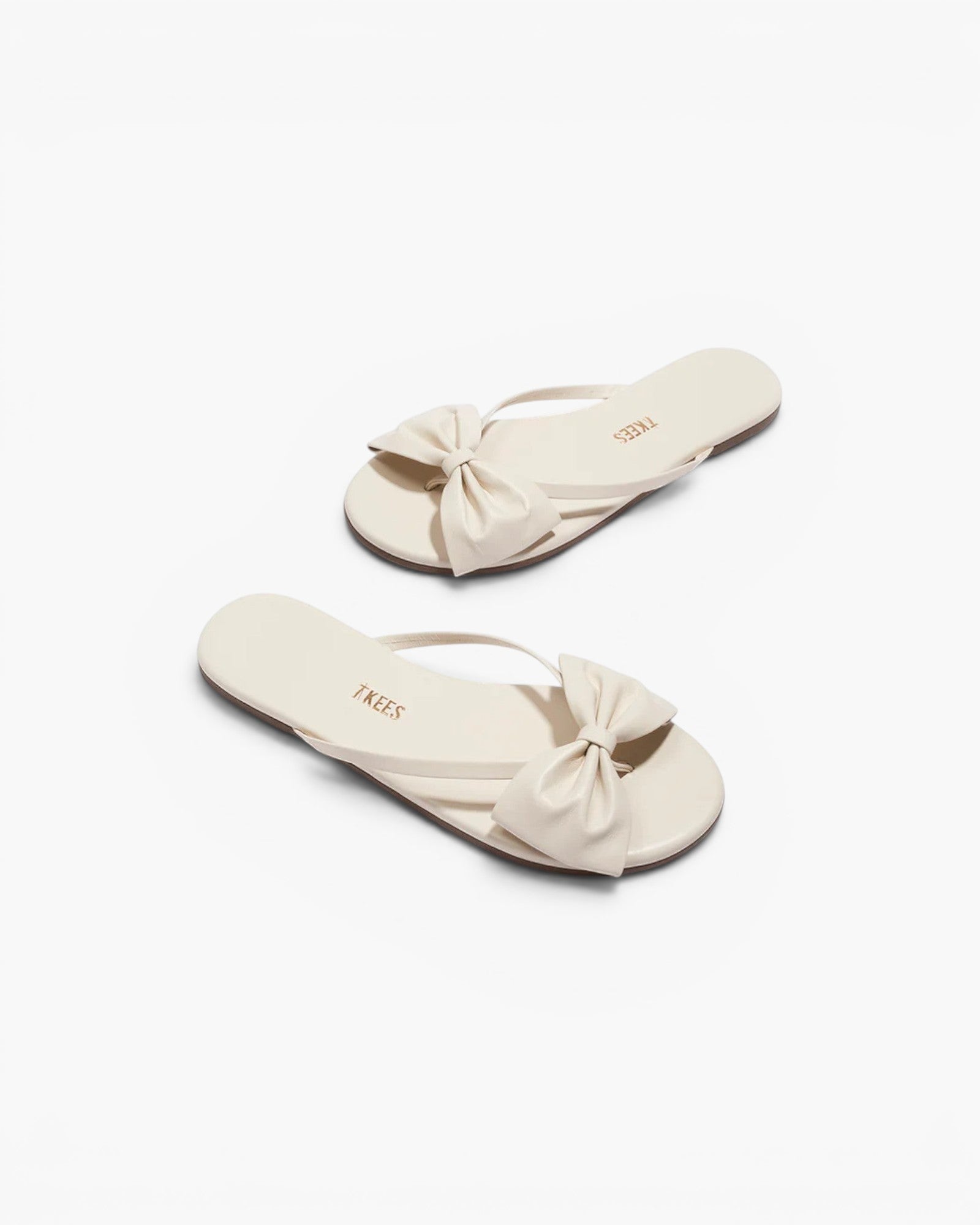 JONES + CO Lily cream leather flip flop sandals featuring an oversized bow detail and cushioned insole.