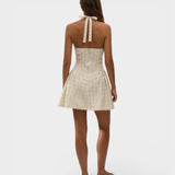 Model wearing JONES + CO Lola mini dress in antique white with a plaid check pattern and halter neck tie back.