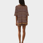 Model wearing JONES + CO Luis Polo Top in Ramona stripe knit with chevron pattern and scalloped hem edges.