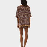 Model wearing JONES + CO Luis Polo Top in Ramona stripe knit with chevron pattern and scalloped hem edges.