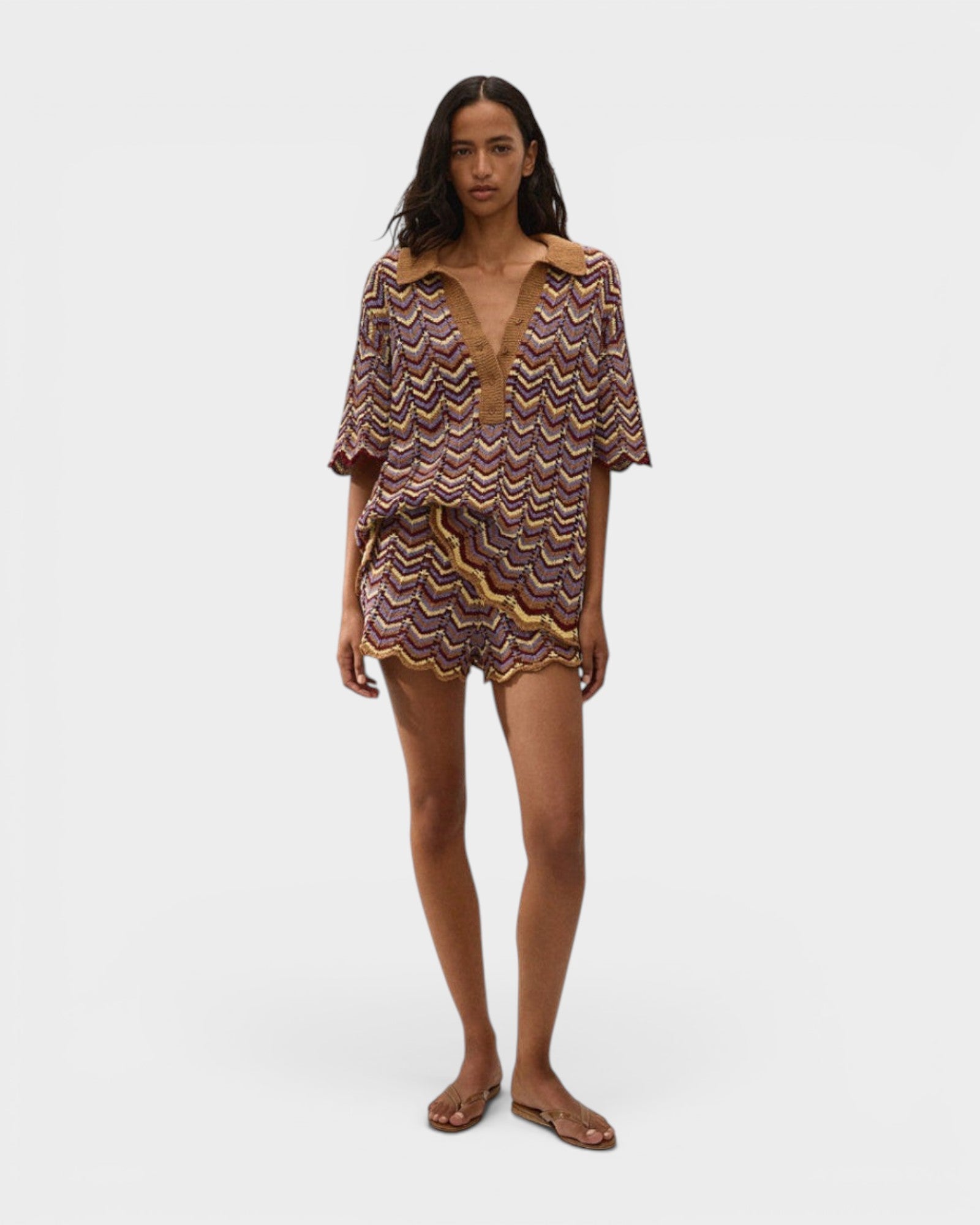 Model wearing JONES + CO Ramona Stripe Luis shorts and matching chevron knit polo shirt in purple and yellow tones.