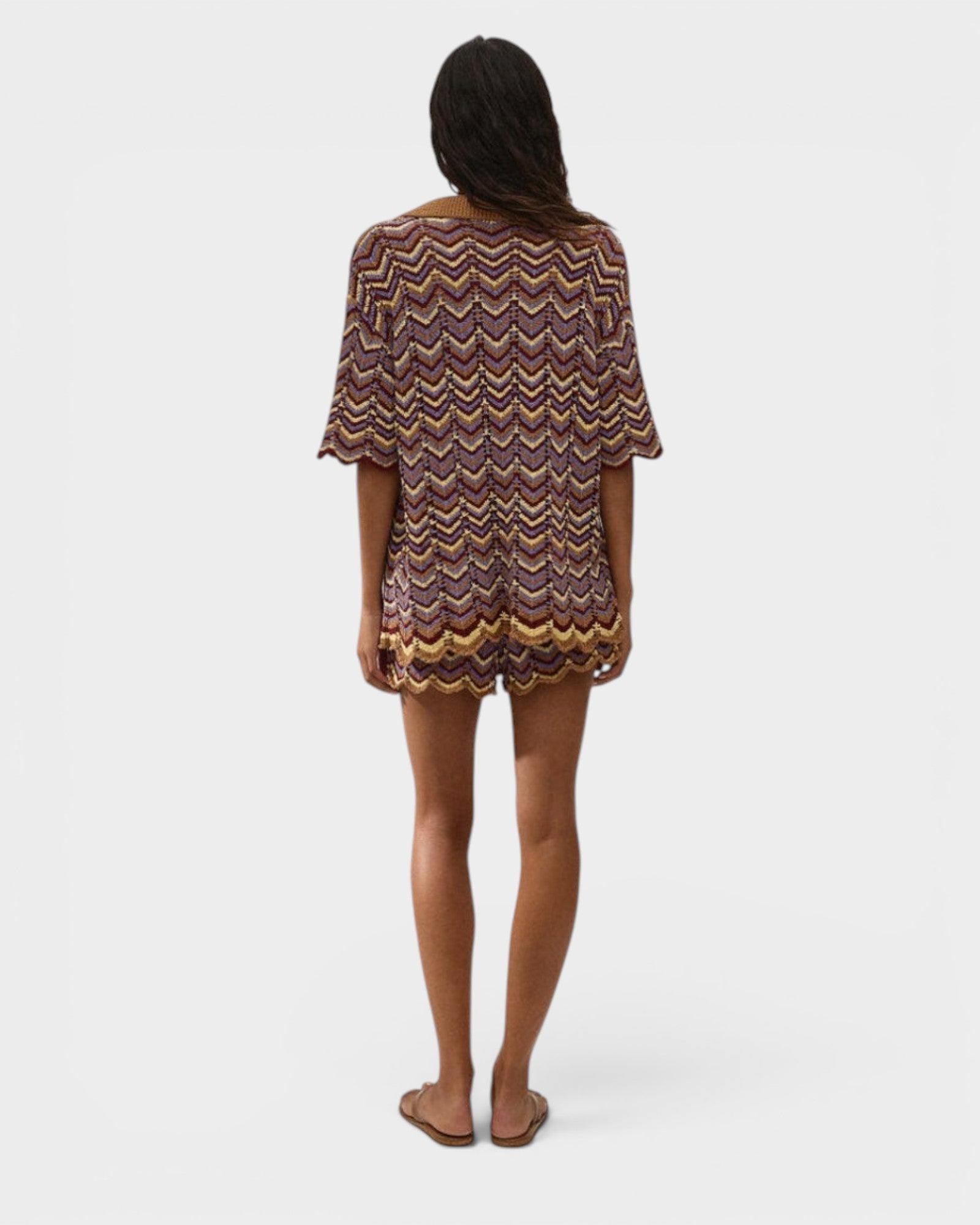 Model wearing JONES + CO Luis Short in Ramona Stripe, a multi-colored chevron knit set with scalloped hem edges.