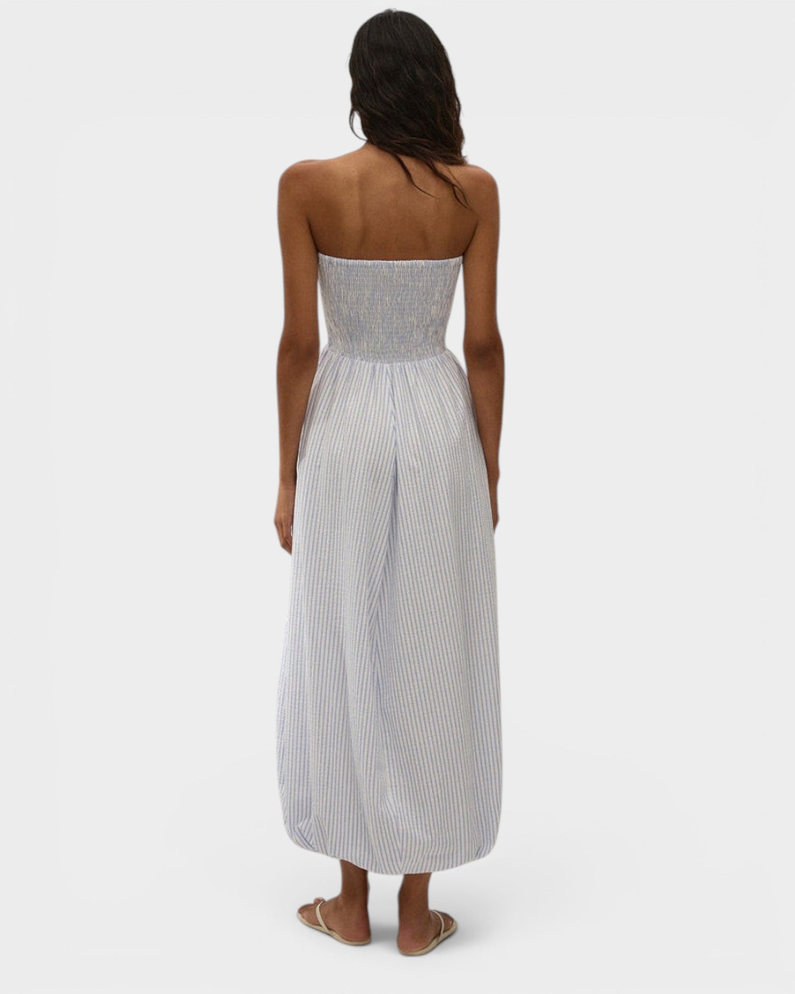 JONES + CO Lunaire strapless midi dress in light blue stripe cotton with a shirred bodice and bubble hem silhouette.