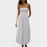 Model wearing JONES + CO light blue striped cotton strapless midi dress with shirred bodice and bubble hem.