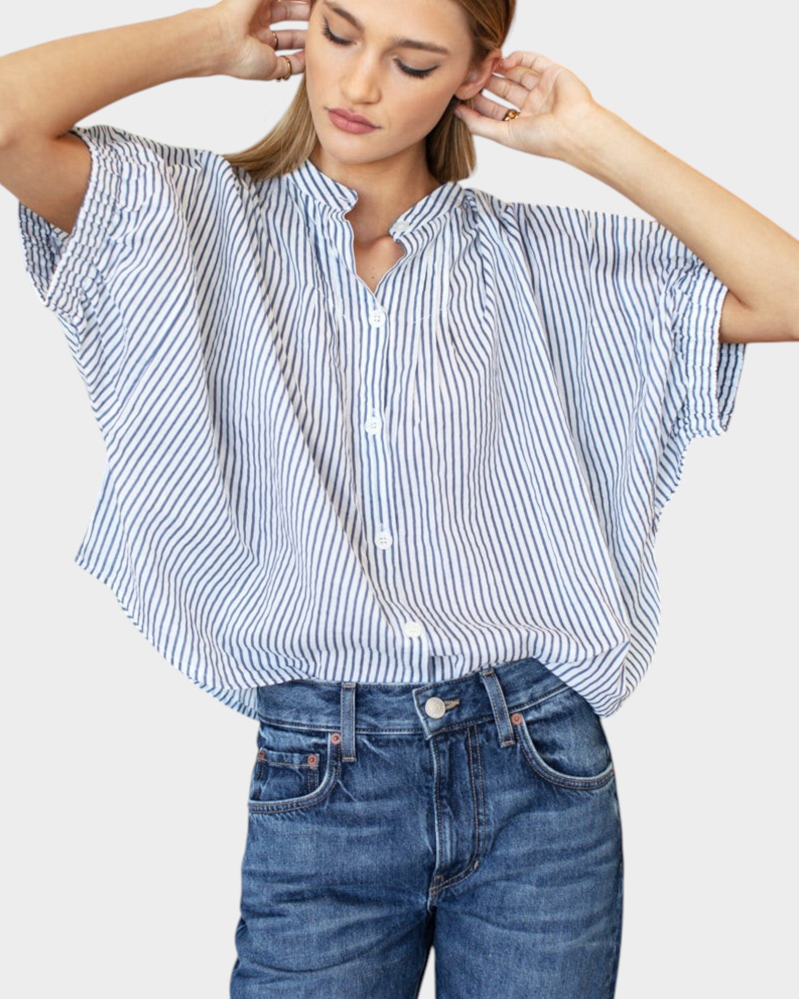 Model wearing a JONES + CO organic cotton blue indigo striped top with mandarin collar and batwing sleeves.