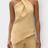 JONES + CO Maria Top in daffodil yellow linen with a halter neck, cross-front detail, and asymmetrical hemline.