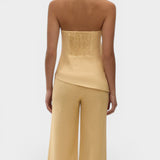 JONES + CO Maria Top in daffodil yellow linen with a halter neck, button closure, and asymmetrical hemline.