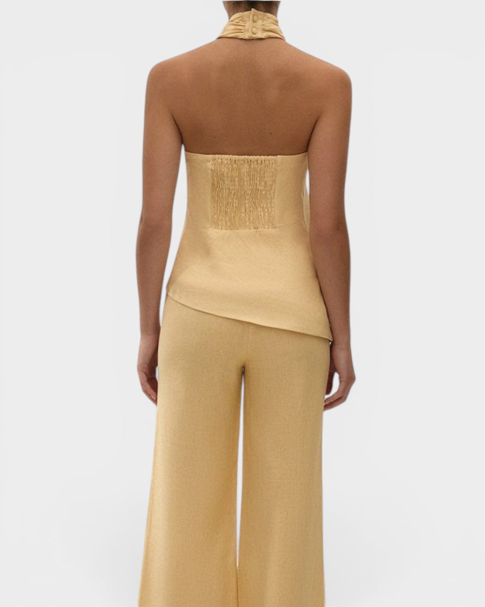 JONES + CO Maria Top in daffodil yellow linen with a halter neck, button closure, and asymmetrical hemline.