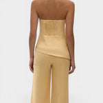 JONES + CO Maria Top in daffodil yellow linen with a halter neck, button closure, and asymmetrical hemline.
