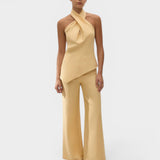 JONES + CO Maria Top in daffodil yellow linen with a halter neck and asymmetrical hem worn by a model.