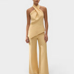 JONES + CO Maria Top in daffodil yellow linen with a halter neck and asymmetrical hem worn by a model.