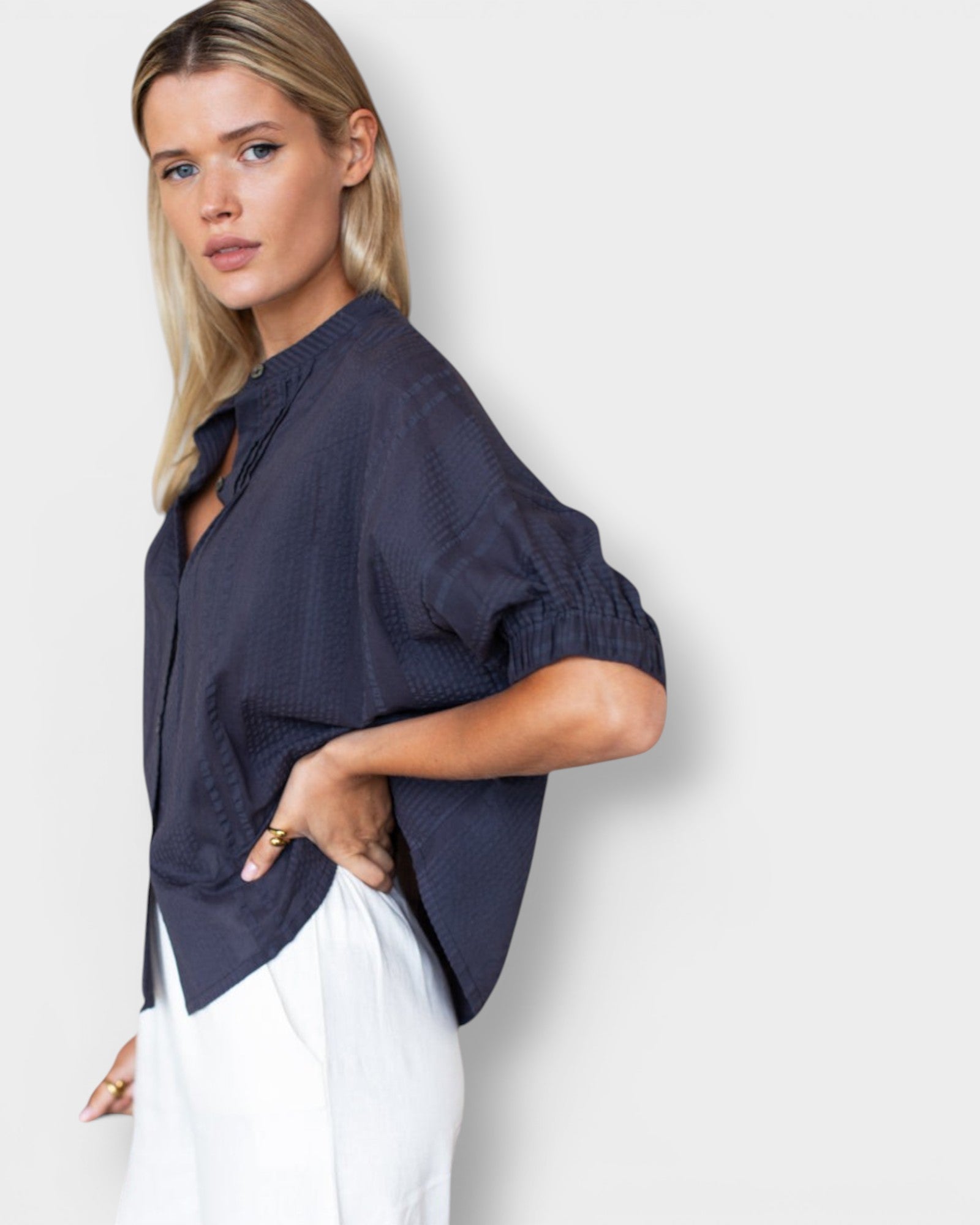 Model wearing a JONES + CO midnight blue organic cotton seersucker mandarin collar top with a relaxed, breezy fit.