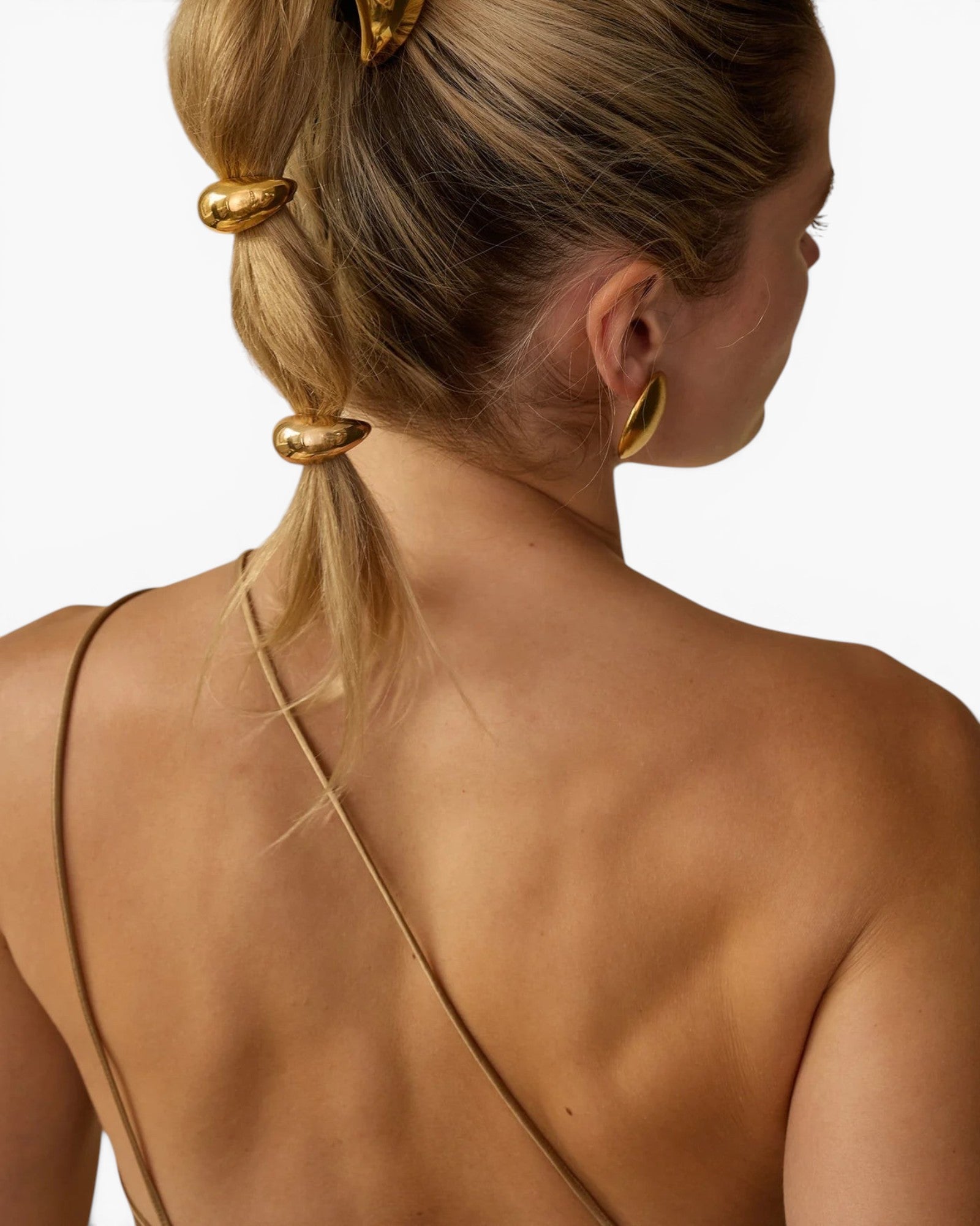 JONES + CO gold mini dome pony cuff hair accessory worn on a model's blonde hair in a bubble ponytail style.