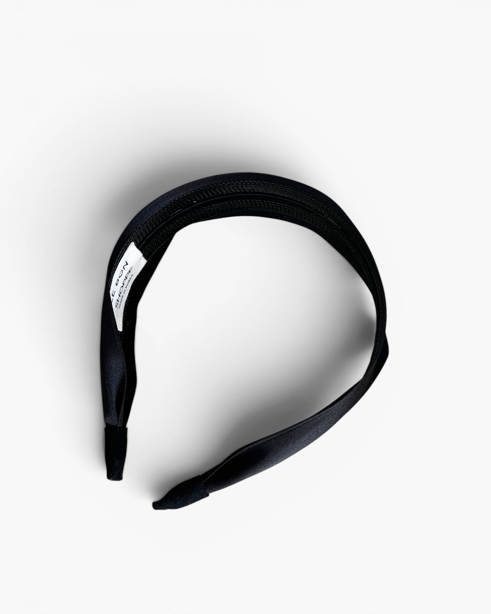 JONES + CO Olivia Headband in ebony black with a sleek fabric finish and comfortable suede-lined ends.