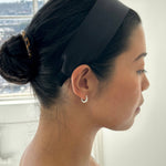 Model wearing a sleek black JONES + CO Olivia Headband in ebony with a comfortable fabric finish.