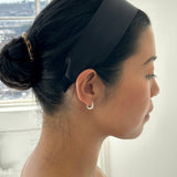 Model wearing a sleek black JONES + CO Olivia Headband in ebony with a comfortable fabric finish.