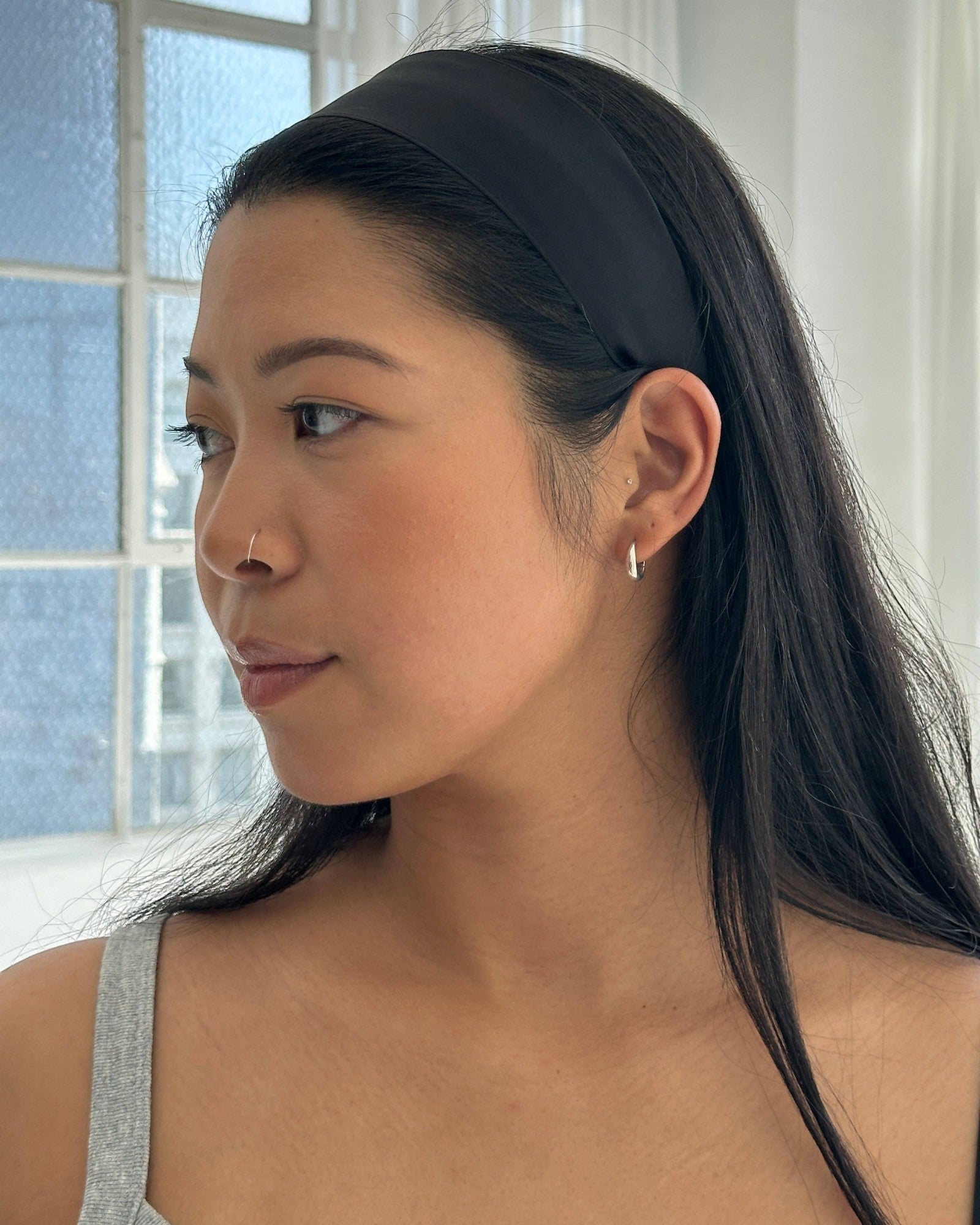 Model wearing a sleek black JONES + CO Olivia Headband with a smooth fabric finish and comfortable fit.
