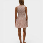 Back view of a model wearing a JONES + CO Palomar mini dress in cinnamon and white check cotton with shirred bodice.
