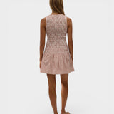 Back view of a model wearing a JONES + CO Palomar mini dress in cinnamon and white check cotton with shirred bodice.
