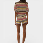 Model wearing JONES + CO Raya high-rise knit shorts in Perla multi-color stripe with a relaxed zig zag hem.