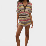 Model wearing JONES + CO Raya Polo Top in Perla multi-colour knit stripe with collar and zig zag hem.