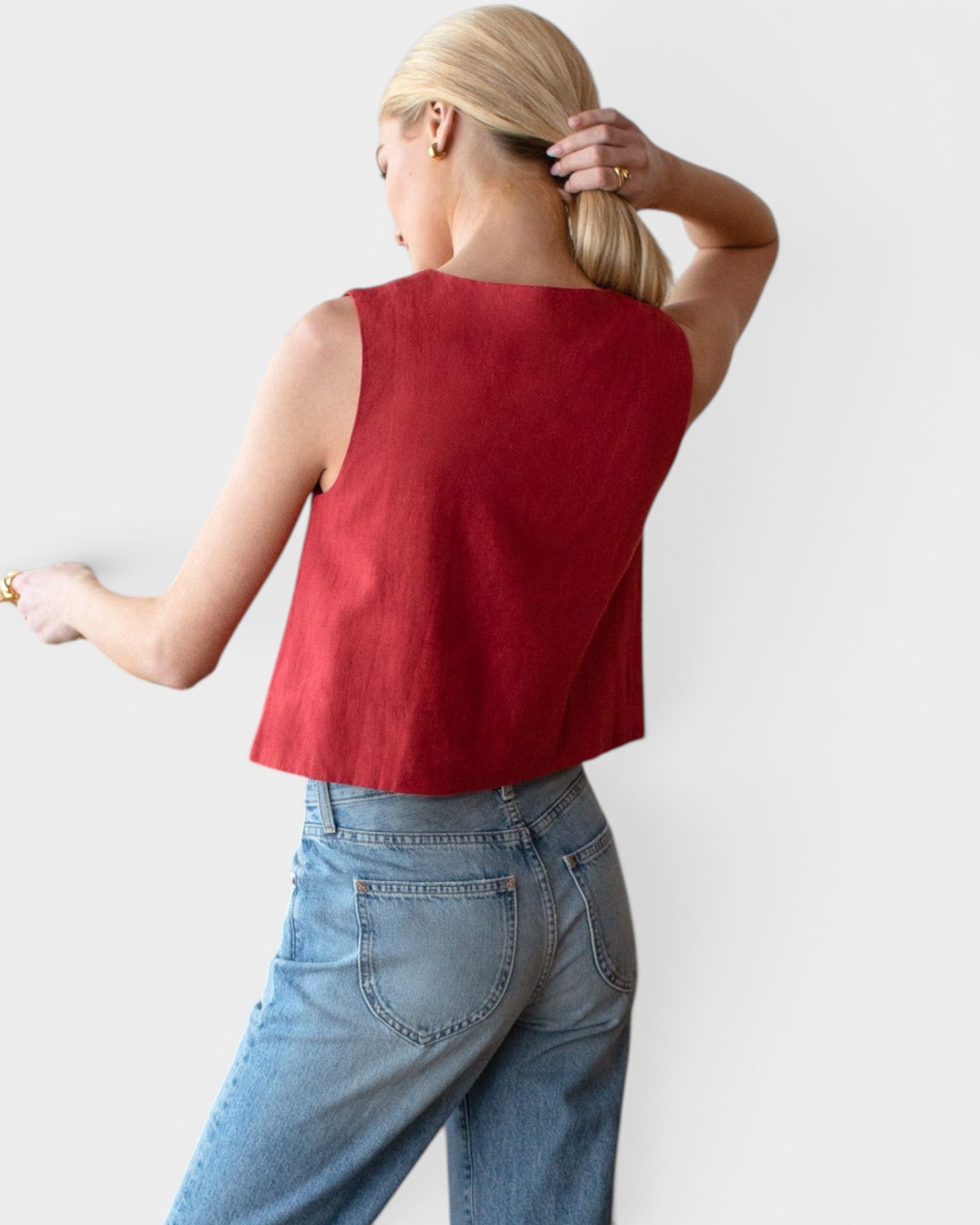JONES + CO sleeveless boxy top in pompeian red linen worn by a model with light blue jeans.
