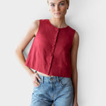 Model wearing a JONES + CO sleeveless Pompeian red linen top with a button-front and boxy silhouette.