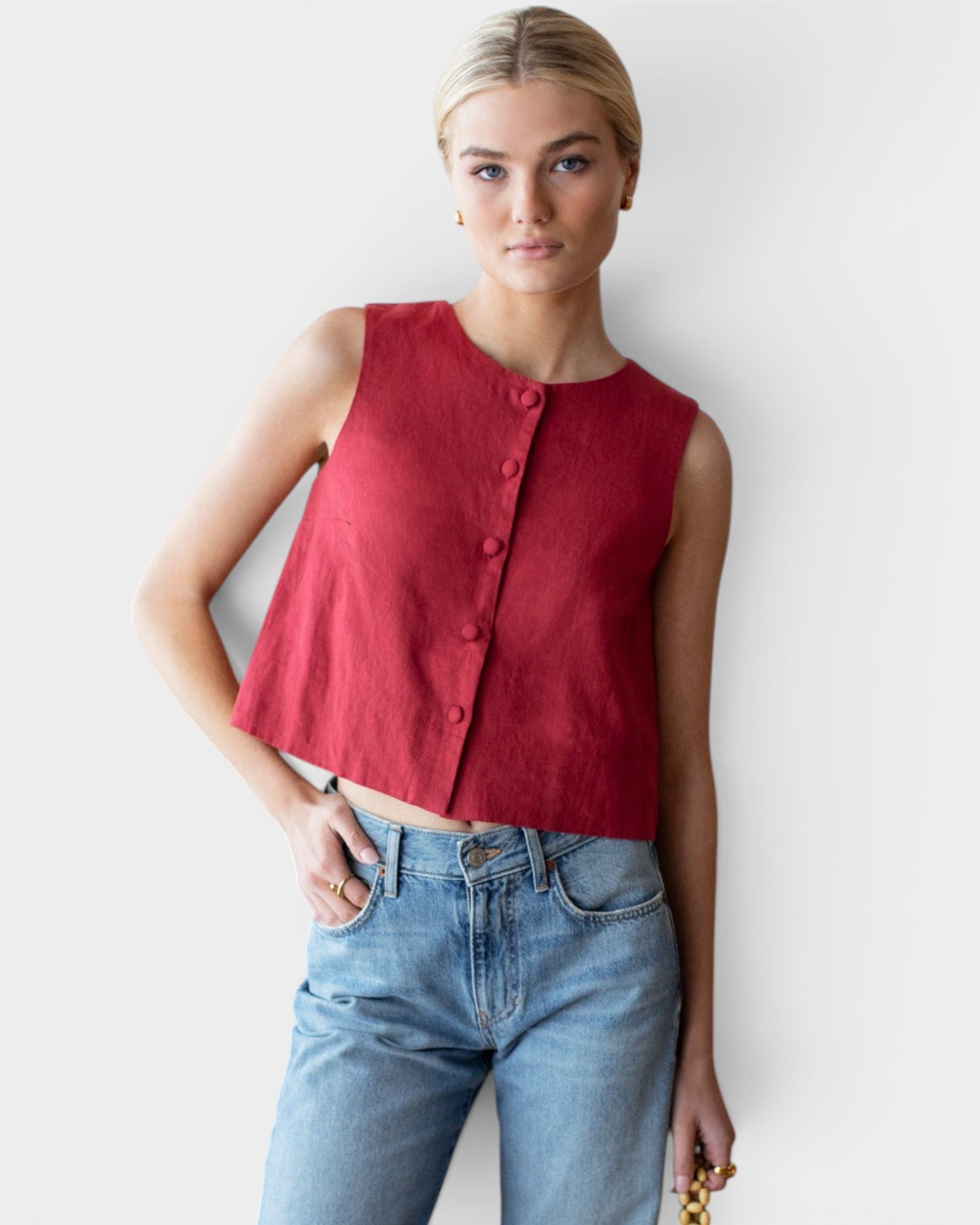 Model wearing a JONES + CO sleeveless Pompeian red linen top with a button-front and boxy silhouette.