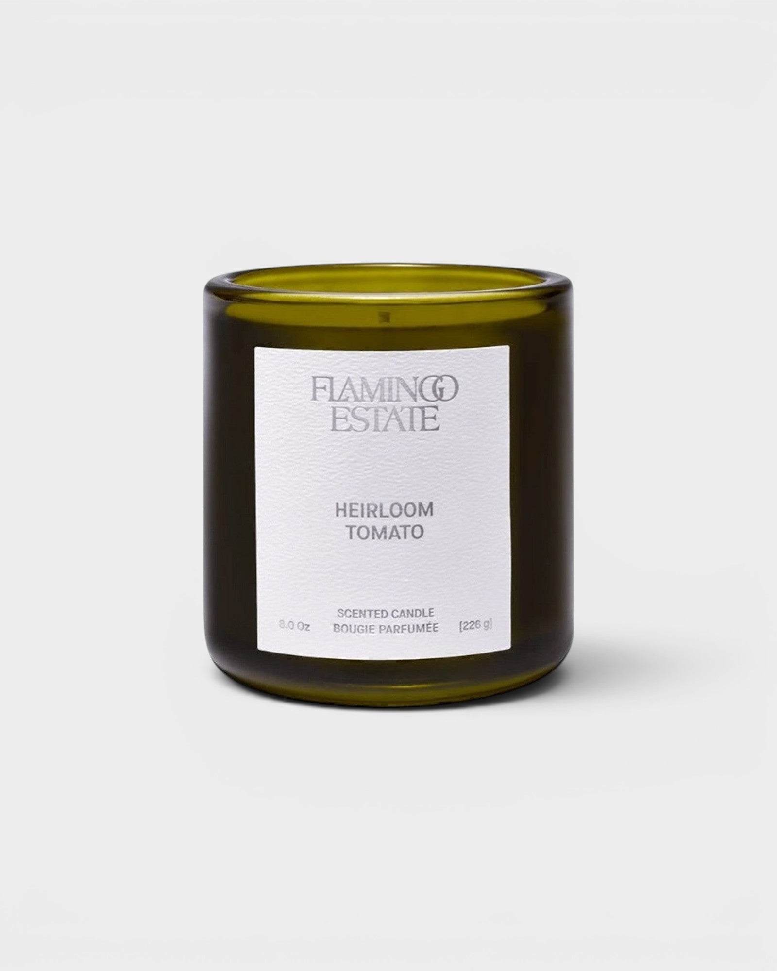 JONES + CO Flamingo Estate Roma Heirloom Tomato scented candle in a dark green glass jar with a white label.