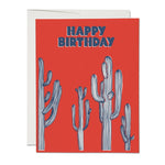 JONES + CO Saguaro Cactus Happy Birthday greeting card with blue striped illustrations on a vibrant red background.