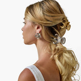 Model wearing JONES + CO Selene stainless steel claw clips in gold and silver with a modern curved design.