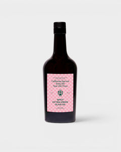 JONES + CO Spicy Extra Virgin Olive Oil in a dark glass bottle with a pink checkered label.