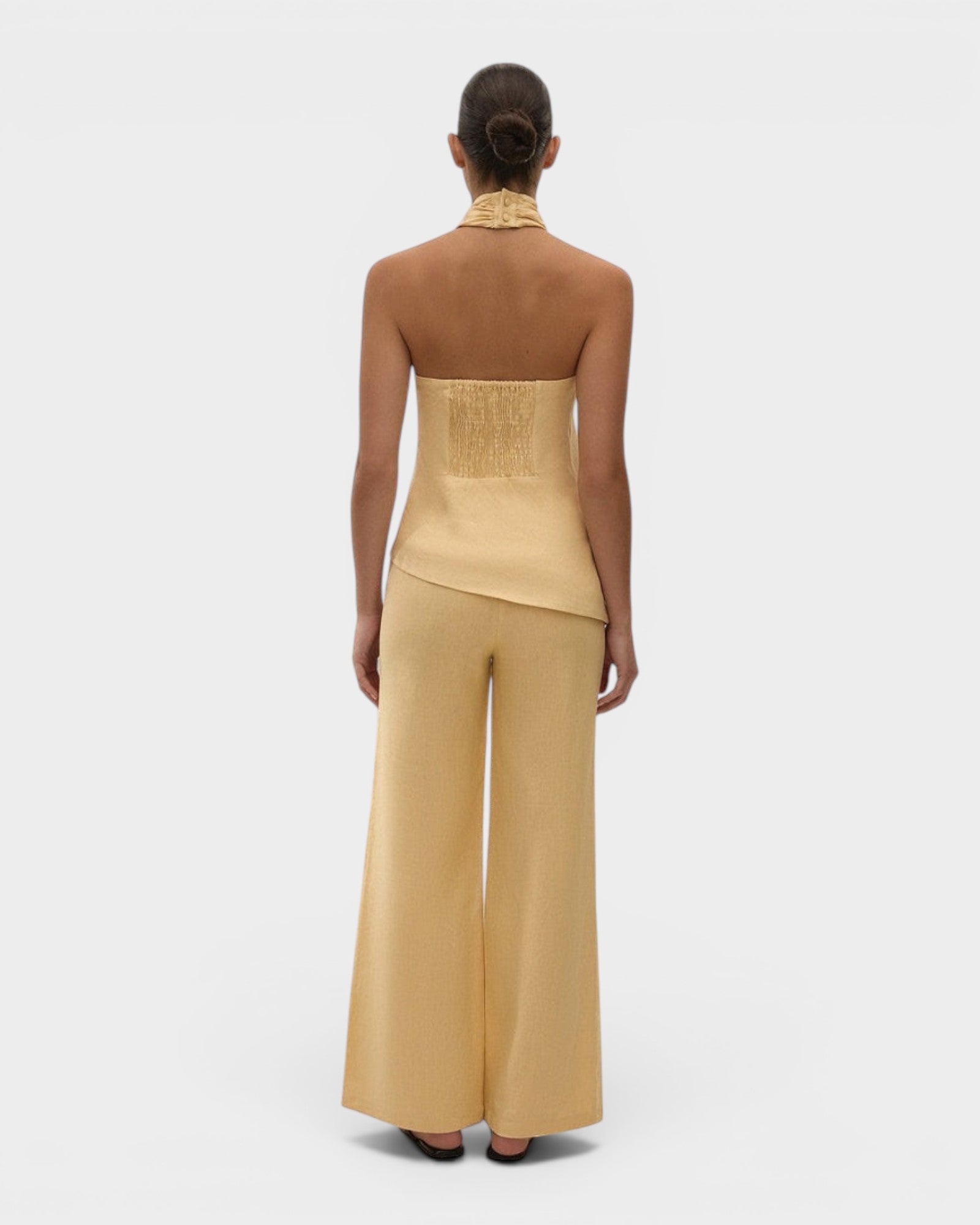 Model wearing JONES + CO Syna wide-leg linen pants in daffodil yellow, featuring a high-rise fit and relaxed silhouette