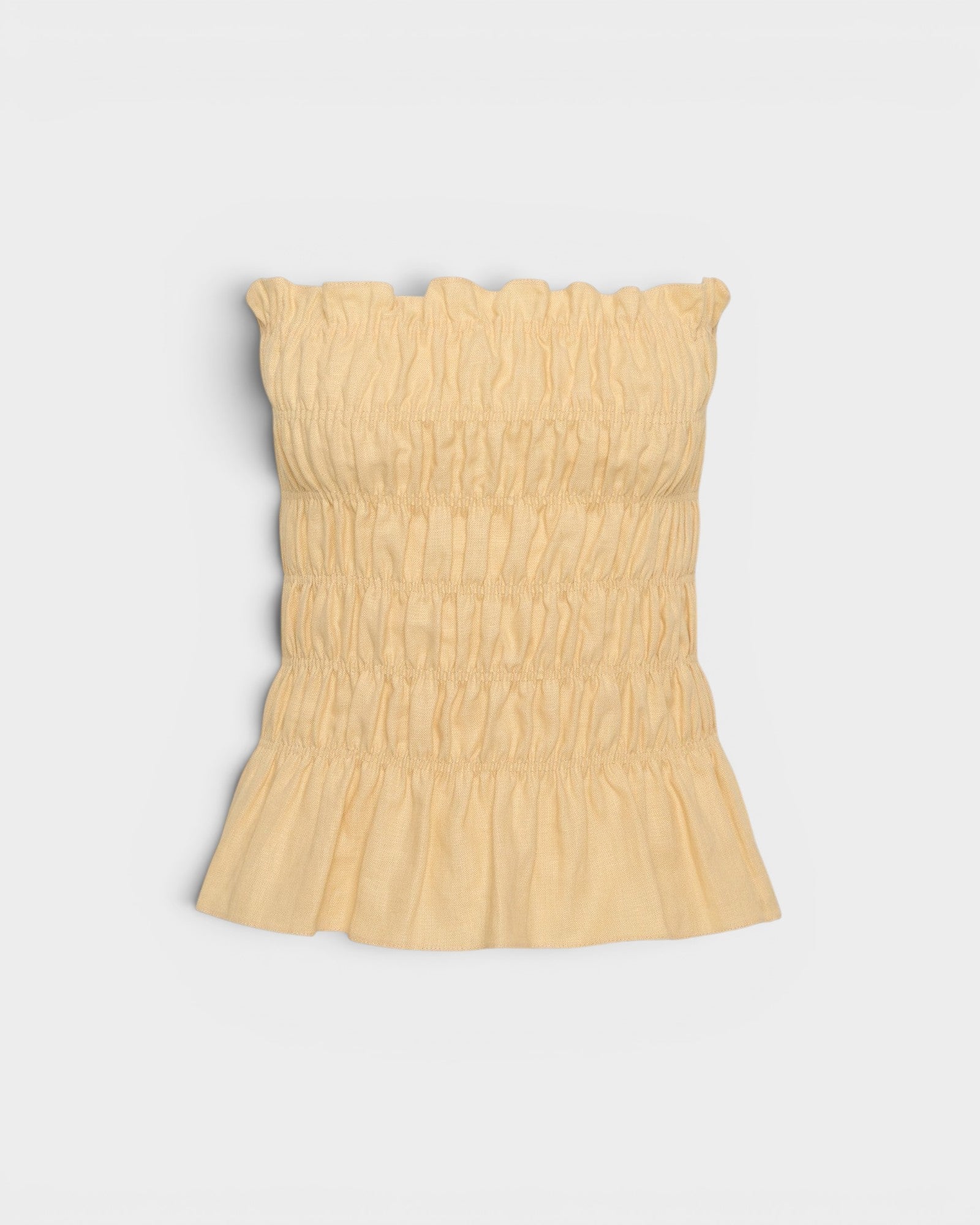JONES + CO Tiera strapless linen top in daffodil yellow with shirred bodice, frilled neckline, and peplum hem.