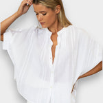 Model wearing a white JONES + CO organic cotton seersucker mandarin collar top with dolman sleeves.