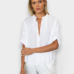 Model wearing a white JONES + CO organic cotton seersucker top with a mandarin collar and dolman half sleeves.
