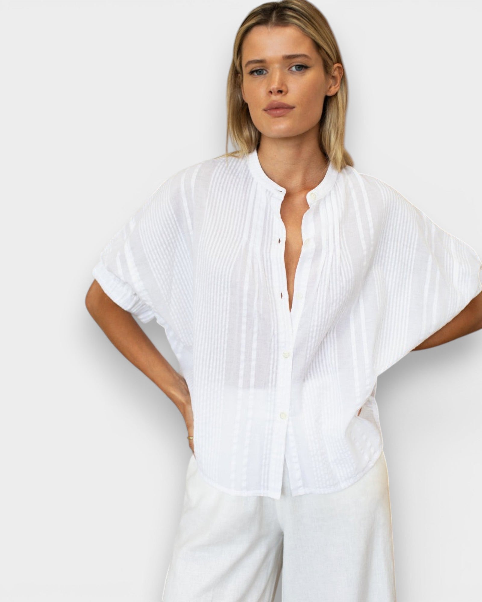 JONES + CO white organic cotton seersucker mandarin collar top with dolman sleeves on a blonde model.